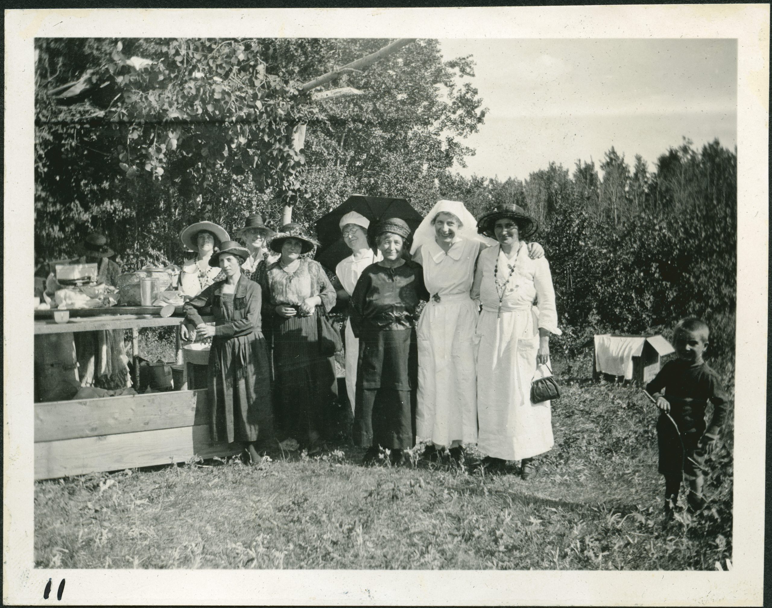 Group of women and a young boy standing outside