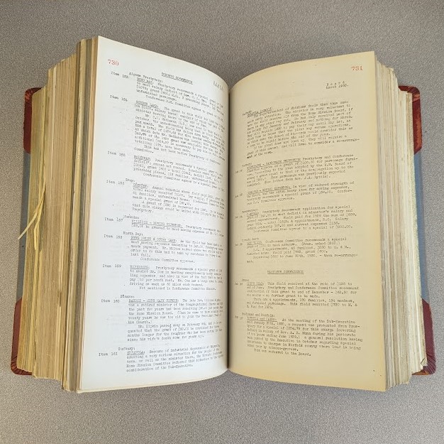 Large bound volume opened in the middle on a grey desk.