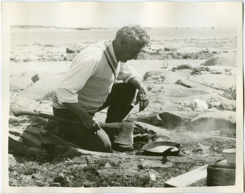 A middle-aged white man cooking bannock outside.